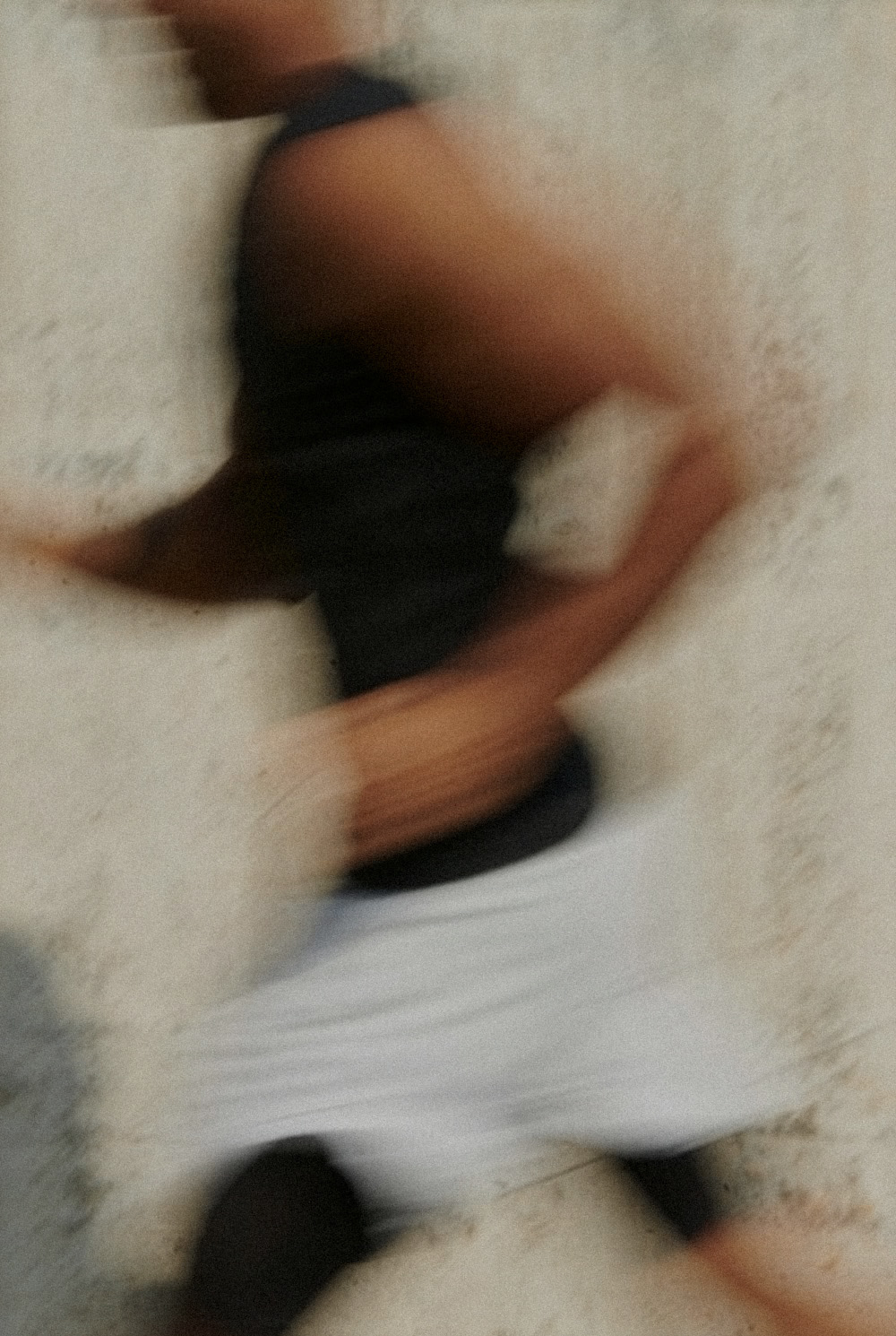 Person beim Training auf einer hellen Fläche, in Bewegungsunschärfe aufgenommen
